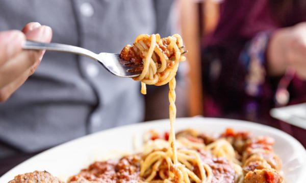 person twirling pasta around a fork